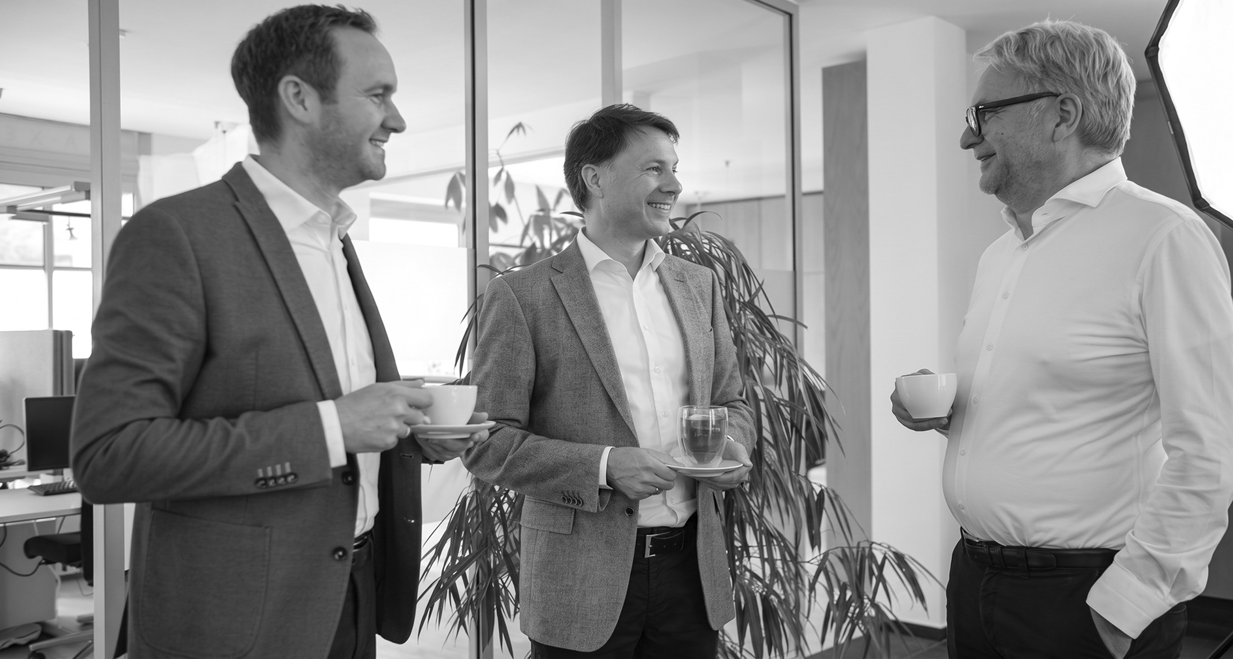 Drei Unternehmer im Gespräch in einem Büro